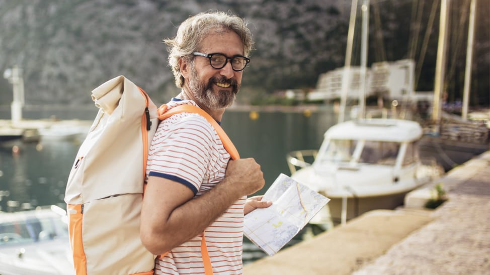Man carrying a soft-sided bag to a sailboat